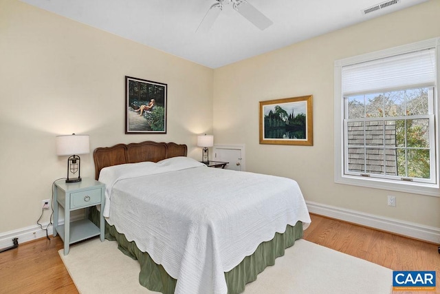 bedroom with visible vents, ceiling fan, baseboards, and wood finished floors