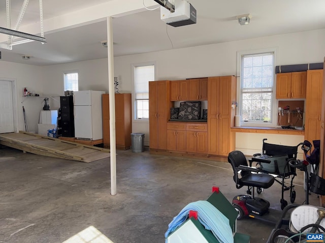 garage with a garage door opener and freestanding refrigerator