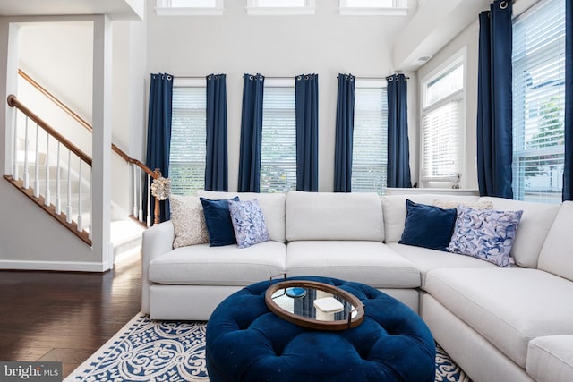 living room with stairs, baseboards, and wood finished floors