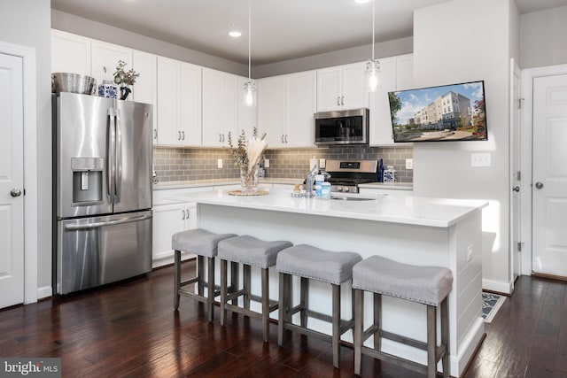 kitchen featuring appliances with stainless steel finishes, light countertops, dark wood-type flooring, and white cabinetry