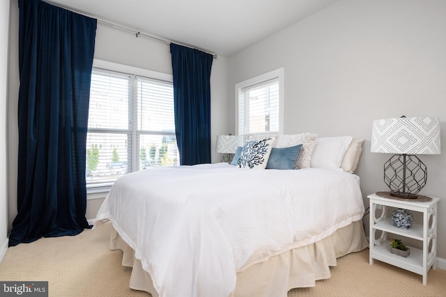 carpeted bedroom with multiple windows and baseboards