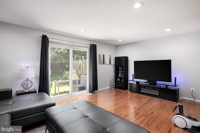 living room featuring recessed lighting, baseboards, and wood finished floors