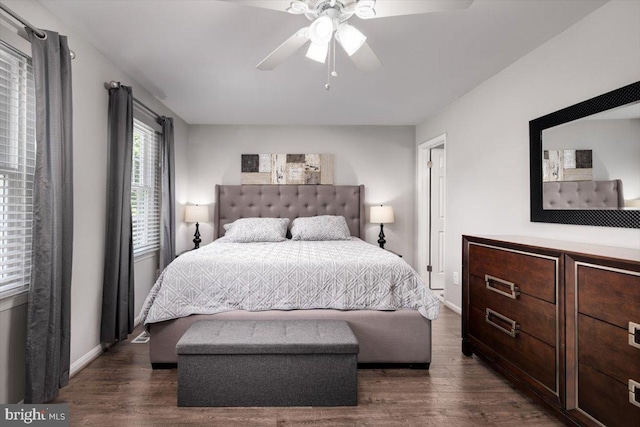 bedroom with dark wood-style floors, ceiling fan, and baseboards