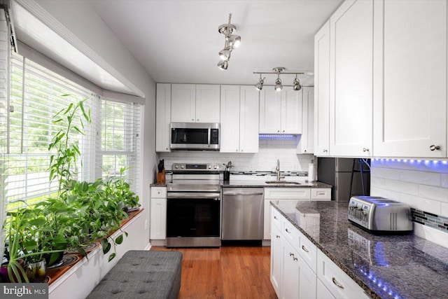 kitchen featuring stainless steel appliances, wood finished floors, and white cabinetry