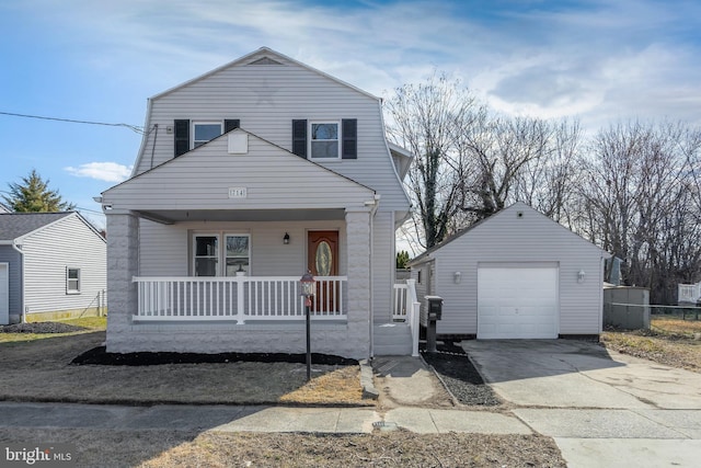 dutch colonial featuring driveway, covered porch, a detached garage, and an outbuilding