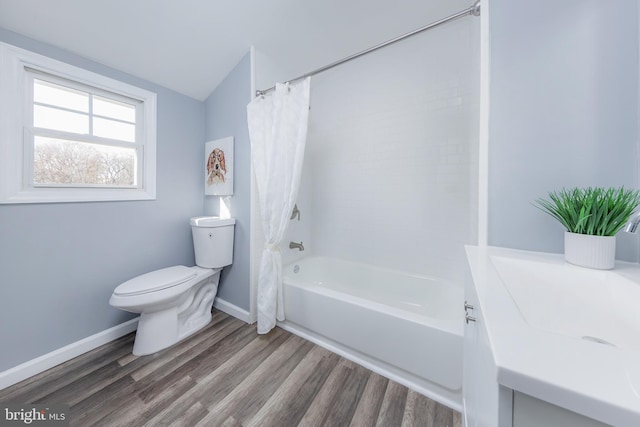 full bathroom featuring baseboards, toilet, wood finished floors, shower / bath combination with curtain, and vanity