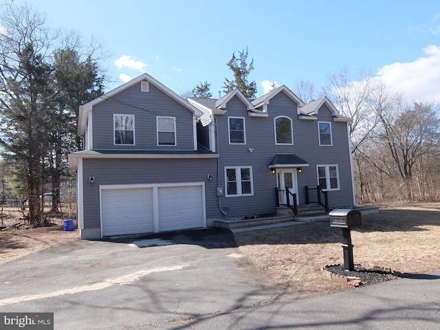 traditional home featuring a garage and aphalt driveway