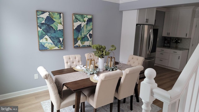 dining room featuring light wood-style flooring and baseboards