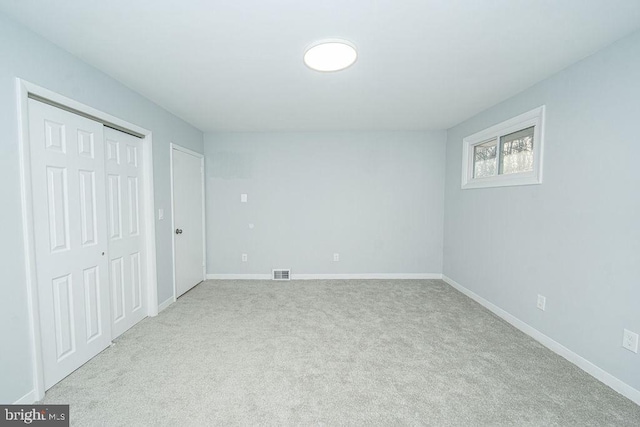 unfurnished bedroom featuring a closet, visible vents, baseboards, and carpet flooring