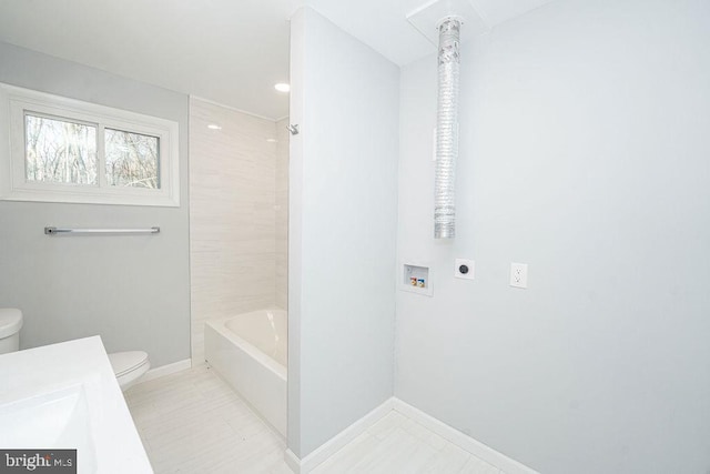 bathroom with bathing tub / shower combination, vanity, toilet, and baseboards