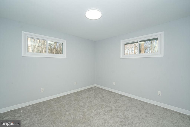 spare room featuring carpet and baseboards