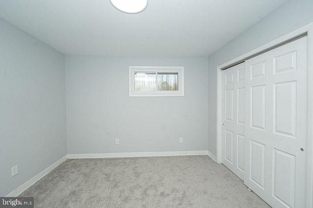 unfurnished bedroom featuring a closet, carpet flooring, and baseboards