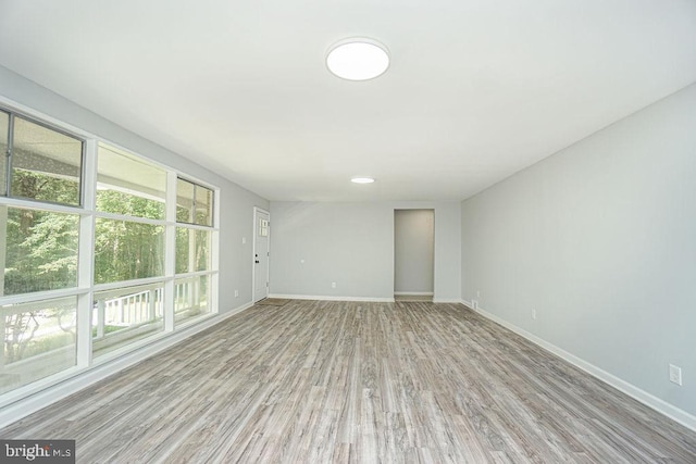 spare room featuring wood finished floors and baseboards