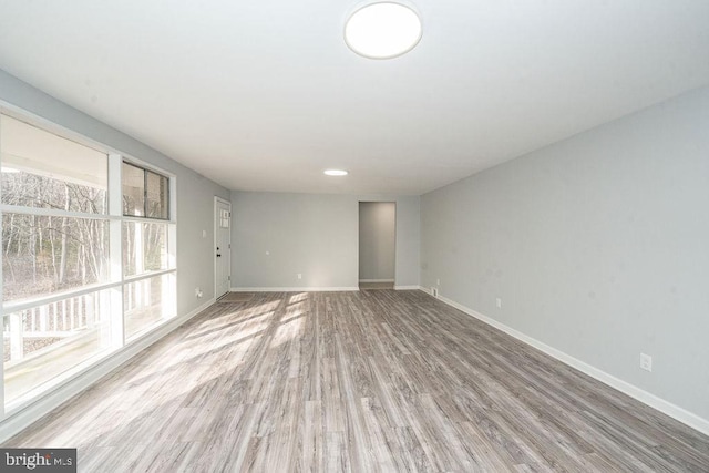 empty room with baseboards and wood finished floors