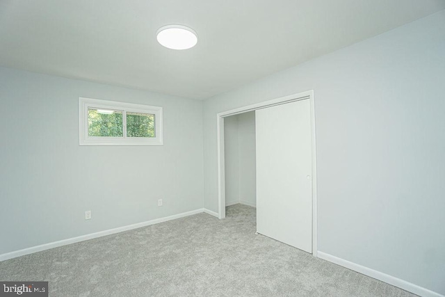 unfurnished bedroom with a closet, carpet flooring, and baseboards