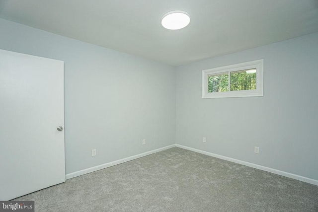 carpeted empty room featuring baseboards