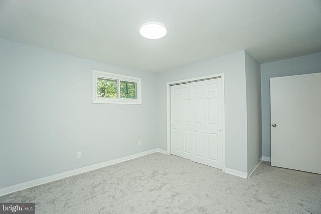 unfurnished bedroom with carpet, baseboards, and a closet