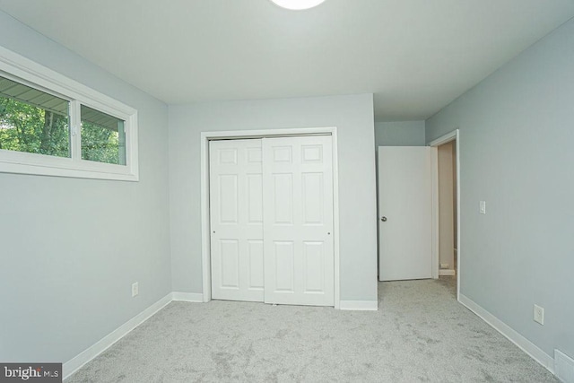 unfurnished bedroom featuring carpet floors, a closet, and baseboards