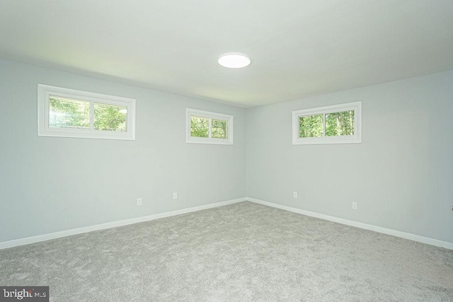 carpeted spare room featuring baseboards