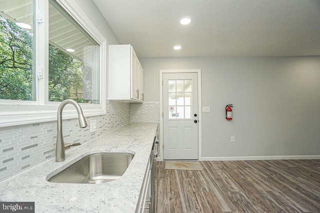 kitchen featuring a sink, white cabinetry, a wealth of natural light, dark wood-style floors, and tasteful backsplash