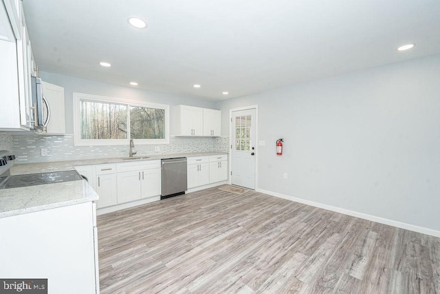 kitchen with white cabinets, tasteful backsplash, stainless steel appliances, and a sink