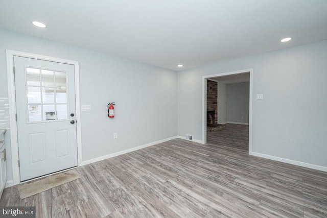 interior space featuring light wood-type flooring, a fireplace, and baseboards