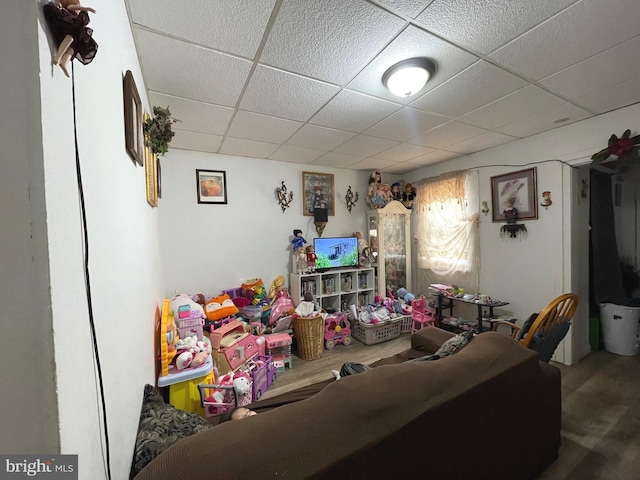 living area featuring a paneled ceiling and wood finished floors