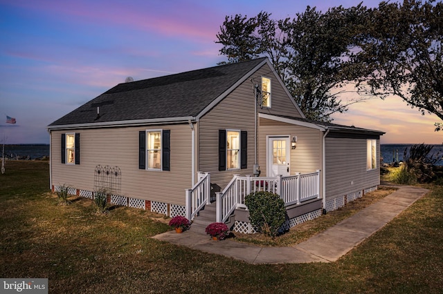 view of front of property with crawl space, a shingled roof, and a front yard