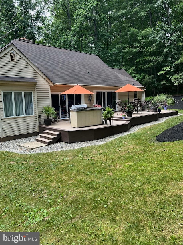 rear view of property with a yard and a deck