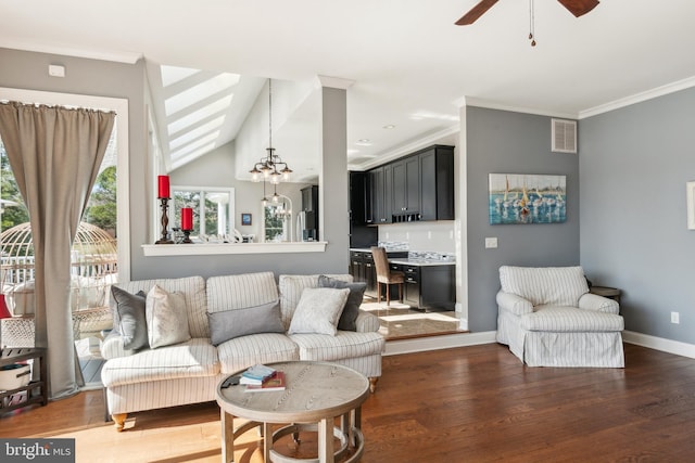 living room with visible vents, ornamental molding, baseboards, and wood finished floors