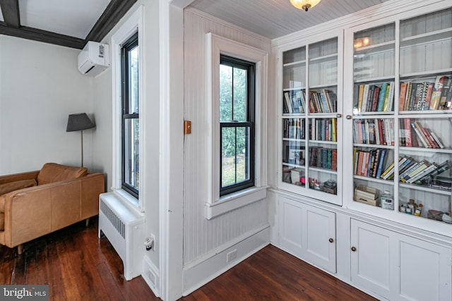 interior space featuring radiator, dark wood finished floors, ornamental molding, and a wall unit AC