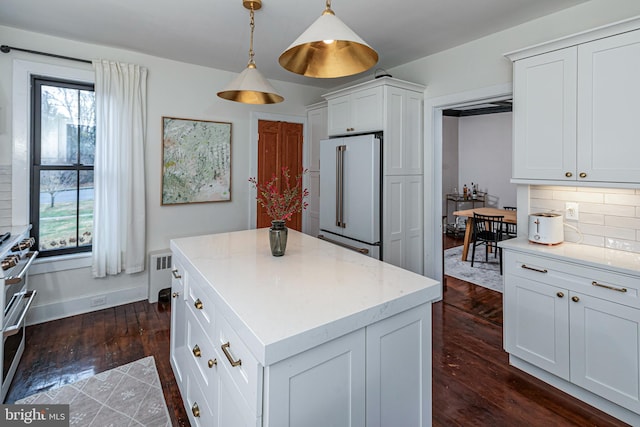 kitchen featuring decorative backsplash, radiator heating unit, a healthy amount of sunlight, and premium appliances