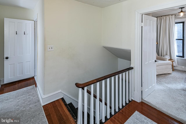 staircase with baseboards and wood finished floors