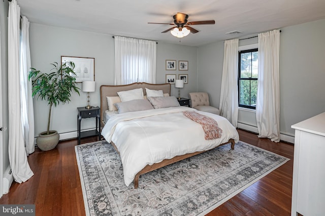 bedroom featuring baseboard heating, dark wood-type flooring, and visible vents