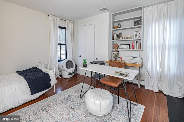 bedroom featuring visible vents and wood finished floors