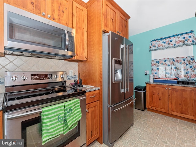 kitchen featuring stainless steel appliances, brown cabinetry, stone countertops, and decorative backsplash