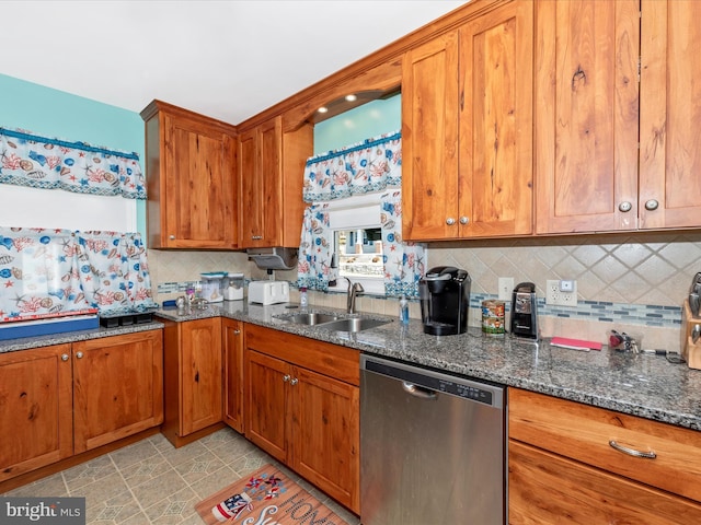 kitchen with dishwasher, dark stone countertops, a sink, and brown cabinets