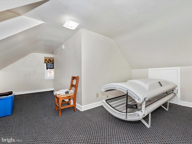 interior space with carpet, vaulted ceiling, and baseboards