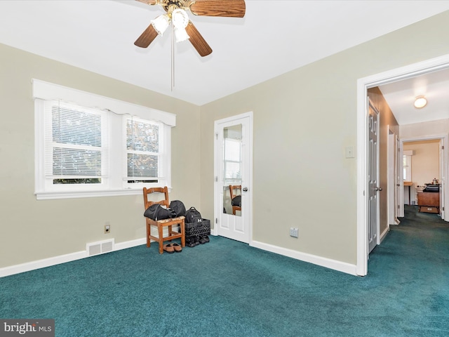 interior space featuring carpet floors, visible vents, ceiling fan, and baseboards