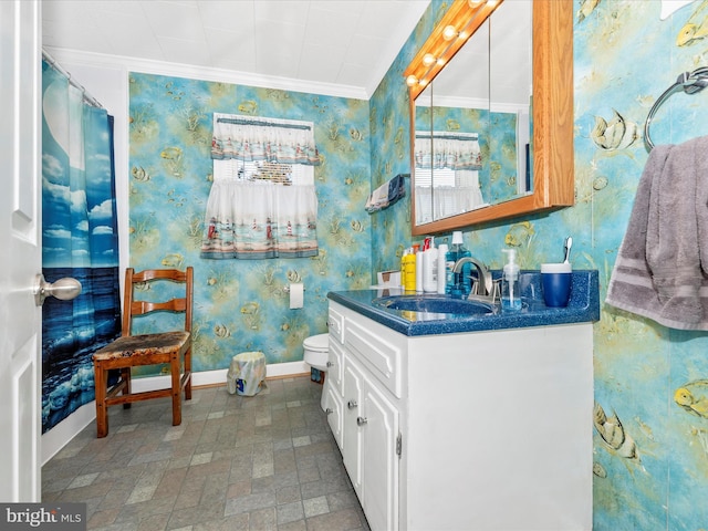 bathroom featuring wallpapered walls, baseboards, toilet, crown molding, and vanity