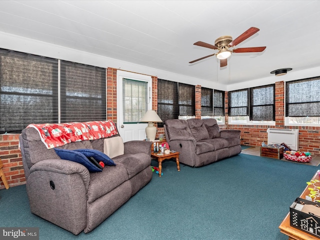 carpeted living room with brick wall, ceiling fan, and a wealth of natural light