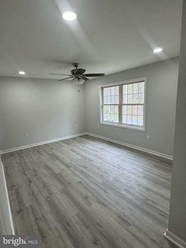 spare room with dark wood-type flooring, recessed lighting, ceiling fan, and baseboards