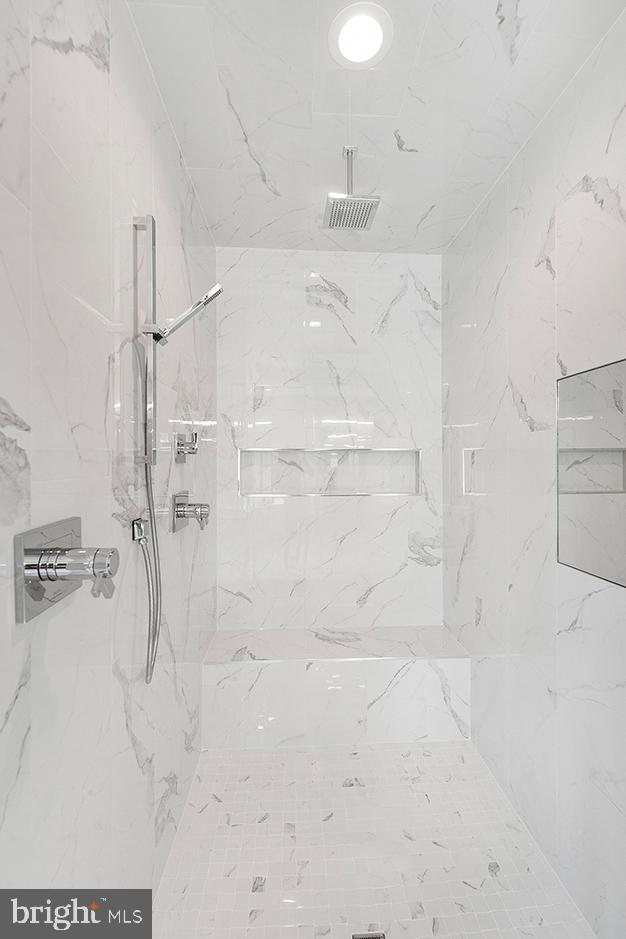 interior space with a marble finish shower