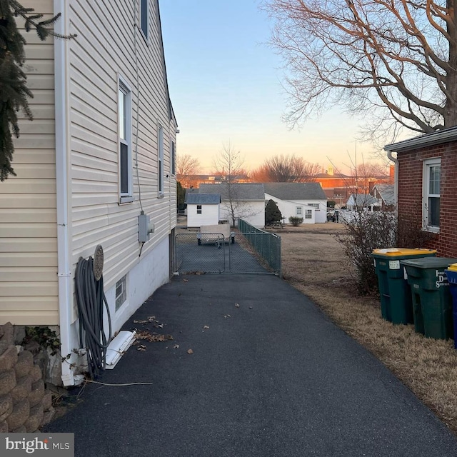 property exterior at dusk with a gate and fence