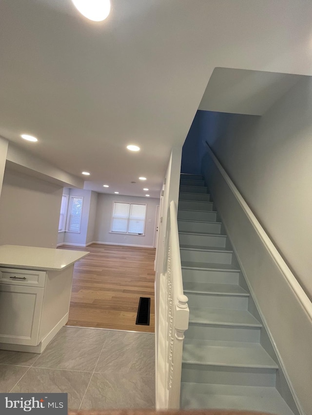 stairway featuring recessed lighting, visible vents, and wood finished floors