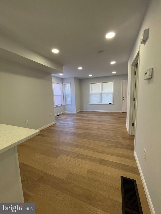 unfurnished room featuring baseboards, light wood-type flooring, visible vents, and recessed lighting