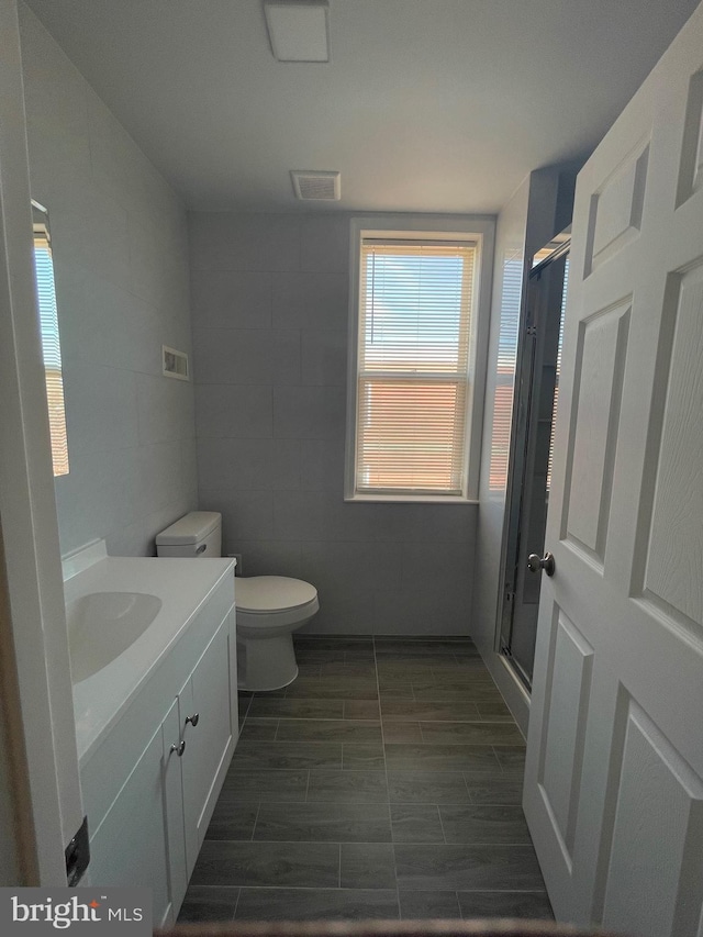 full bathroom with toilet, visible vents, a shower stall, and vanity