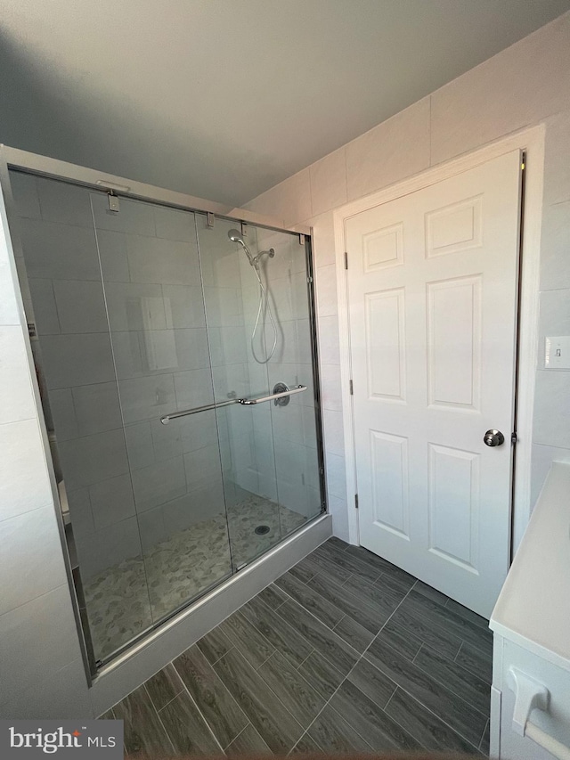 full bath featuring a stall shower and wood tiled floor