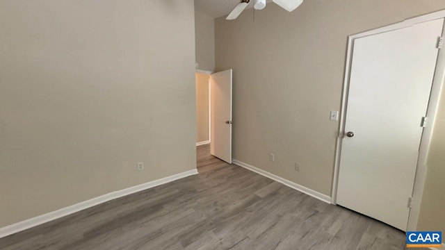 unfurnished bedroom with ceiling fan, wood finished floors, and baseboards