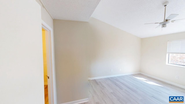 empty room featuring ceiling fan, a textured ceiling, baseboards, and wood finished floors